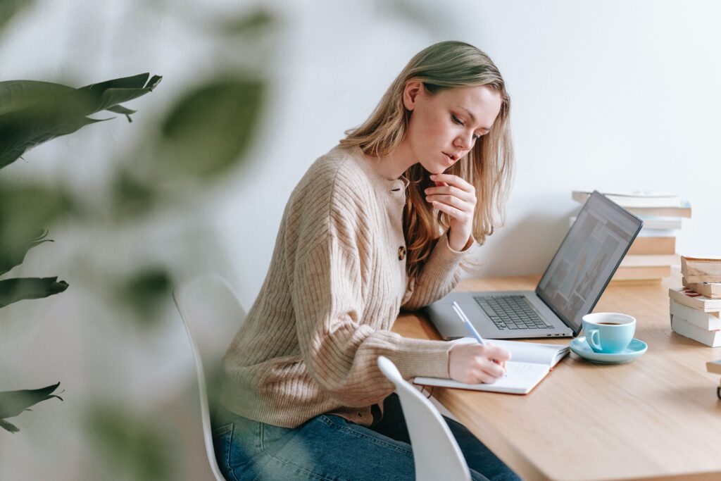 Self-employed business owner working through paperwork at her desk